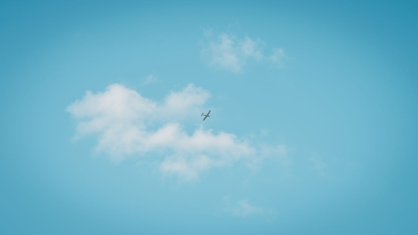 Small white plane in the blue sky