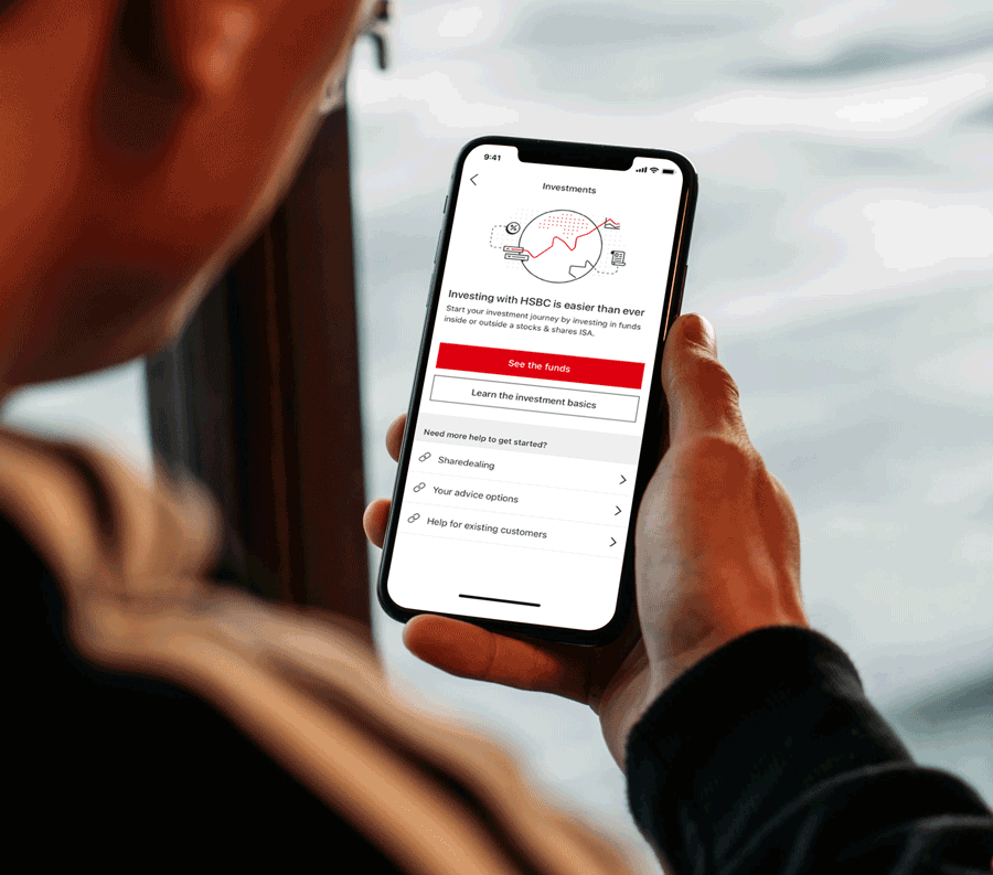 male person holding a mobile phone, looking at the HSBC investment app